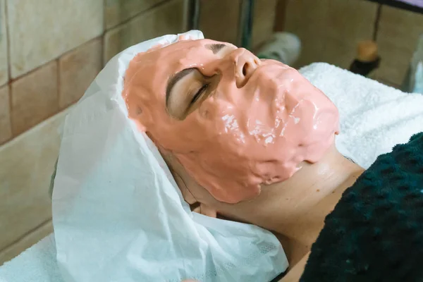 Girl with a cosmetic mask in a spa salon. Face mask application. Spa facial massage — 스톡 사진