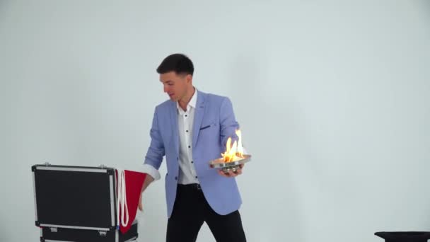 Goochelaar in een pak toont een truc met twee duiven op een witte achtergrond — Stockvideo