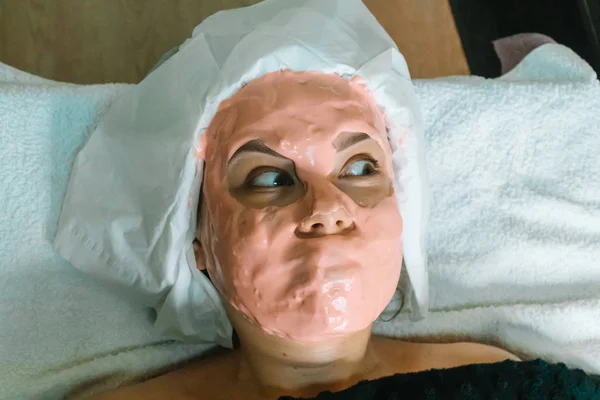 Girl with a cosmetic mask in a spa salon. Face mask application. Spa facial massage — 스톡 사진