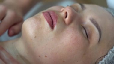Massage therapist is doing manual massage on clients face. Spa facial massage
