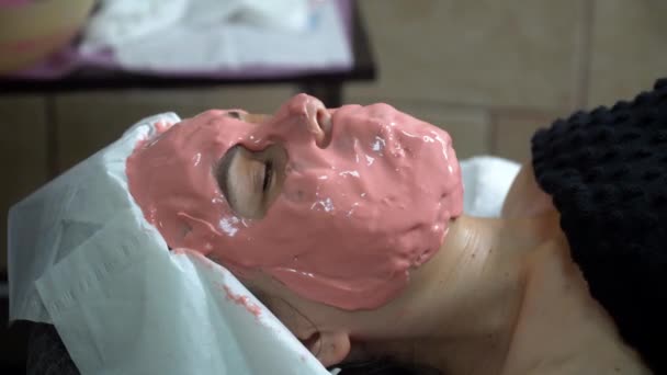 El cosmetólogo aplica una máscara cosmética. Aplicación máscara facial — Vídeos de Stock