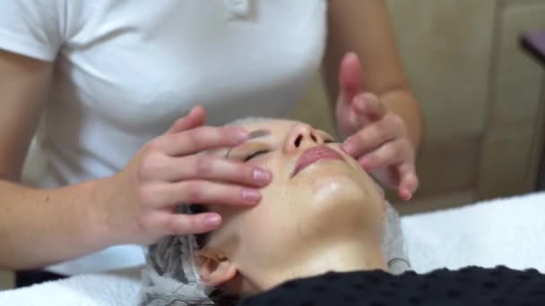 Masajista está haciendo masaje manual en la cara de los clientes. Spa masaje facial — Vídeos de Stock