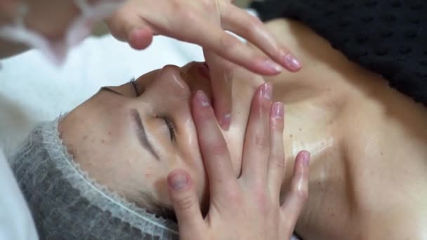 Masajista está haciendo masaje manual en la cara de los clientes. Spa masaje facial — Vídeos de Stock