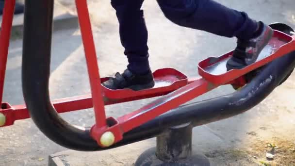 Little boy on street public sports training equipment — Stockvideo