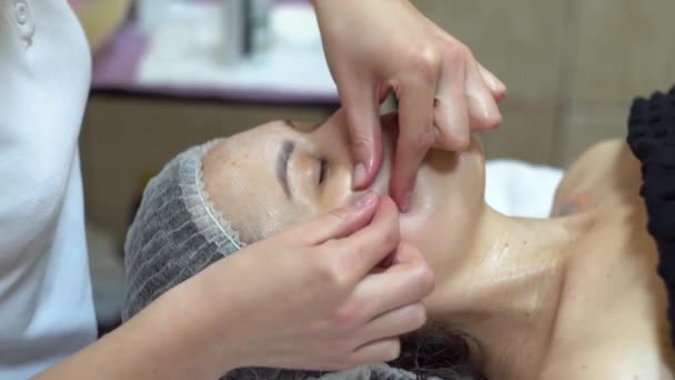 O terapeuta de massagens está a fazer massagens manuais no rosto dos clientes. Spa massagem facial — Vídeo de Stock