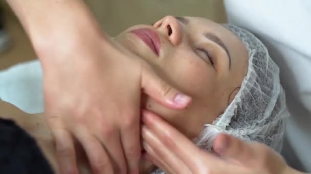 Масажист проводить ручний масаж обличчя клієнтів. Лікування краси обличчя. Спа масаж обличчя — стокове відео