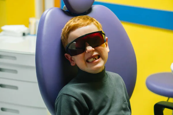 Scared red-haired boy crying at reception at dentist in dental chair — Stock Photo, Image