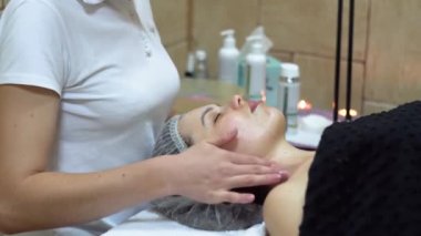 Massage therapist is doing manual massage on clients face. Spa facial massage