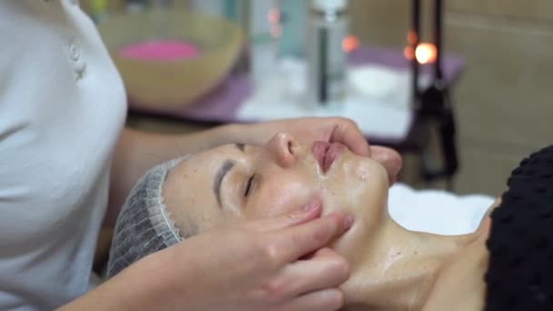 Masážní terapeut provádí manuální masáž obličeje klientů. Lázeňská masáž obličeje — Stock video