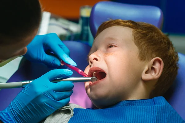 Verängstigter rothaariger Junge weint beim Empfang beim Zahnarzt im Zahnarztstuhl — Stockfoto