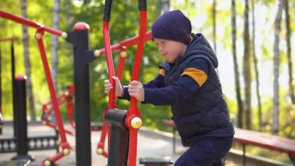 Рыжий мальчик занимается спортивными упражнениями на улице. Детский спорт — стоковое видео