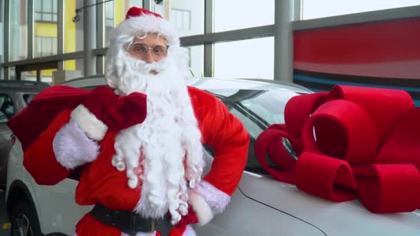 Weihnachtsmann in einem Autohaus. Weihnachtsmann kauft ein Auto — Stockvideo
