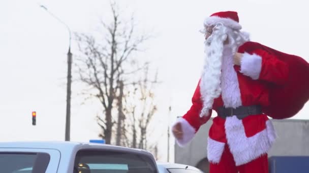 O Pai Natal na parte de trás de uma carrinha. Papai Noel em uma concessionária de carros — Vídeo de Stock