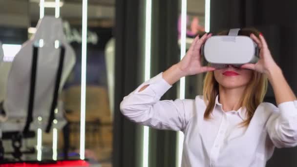 Una mujer con gafas de realidad virtual. Instalación de realidad virtual en segundo plano — Vídeo de stock