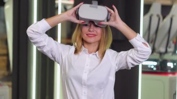 Een vrouw met een Vr bril. Virtual reality installatie op de achtergrond — Stockvideo