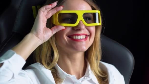 Женщина смотрит захватывающий фильм в кинотеатре в 3D очках — стоковое видео