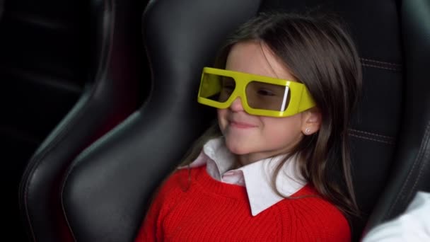 Little girl watching thrilling movie at cinema with 3D glasses — Stock Video