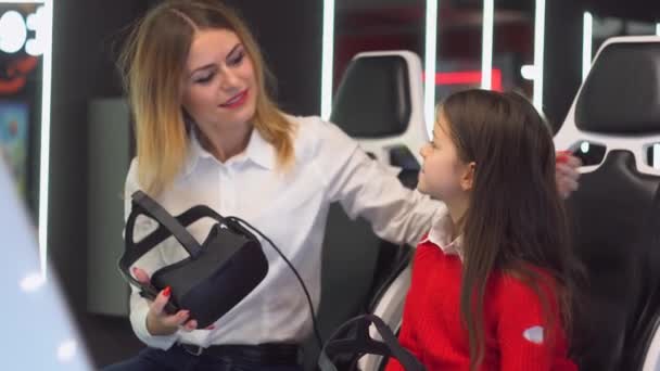 Femme et petite fille se préparent à commencer à jouer simulateur de réalité virtuelle — Video