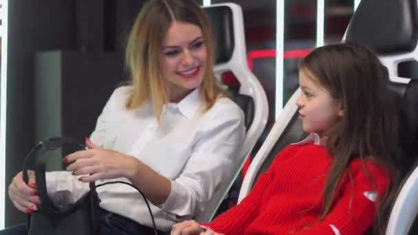 Woman and little girl are getting ready to start playing virtual reality simulator — 비디오