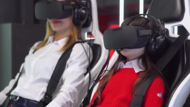 Vrouw en klein meisje met Vr bril rijdt virtual reality simulator — Stockvideo