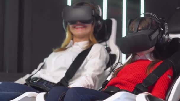 Woman and little girl with VR glasses rides virtual reality simulator — 비디오