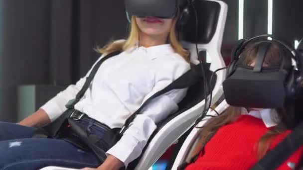 Kvinna och liten flicka med Vr glasögon rider virtuell verklighet simulator — Stockvideo