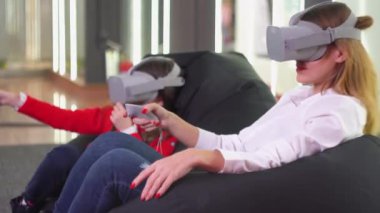 Küçük kız ve kadın gözlüklü Vr simülatörü oynuyorlar