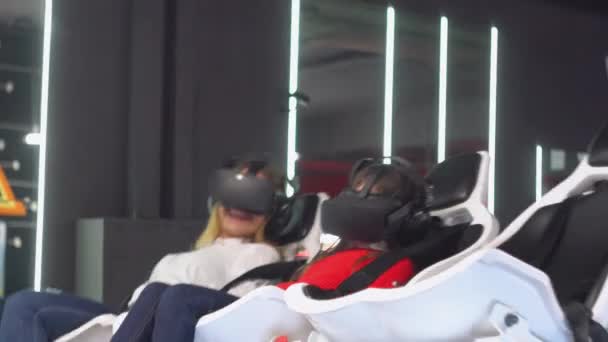 Vrouw en klein meisje met Vr bril rijdt virtual reality simulator — Stockvideo