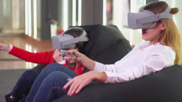 Klein meisje en vrouw spelen Vr simulator met bril — Stockvideo