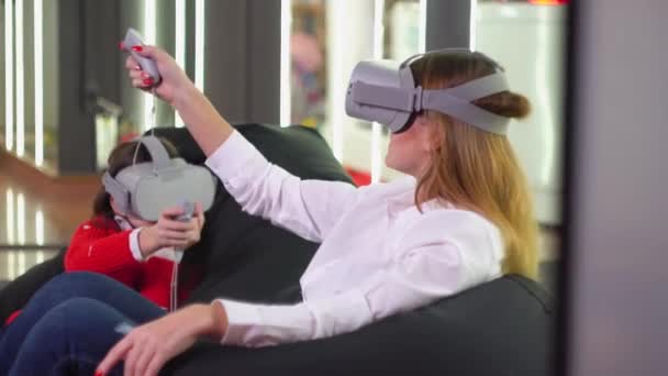Petite fille et femme jouant VR simulateur avec des lunettes — Video