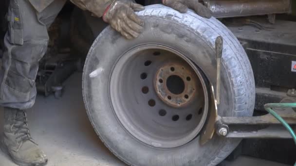 Tamirci aracın lastiğini patlattı. Lastik değiştiricinin yardımıyla alaşımlı tekerden lastik çıkarma işlemi. Kış lastikleri — Stok video