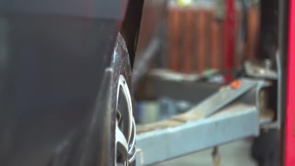 Plataforma hidráulica dejando un coche abajo en el taller de reparación de automóviles. Servicio, reparación y mantenimiento de automóviles — Vídeo de stock