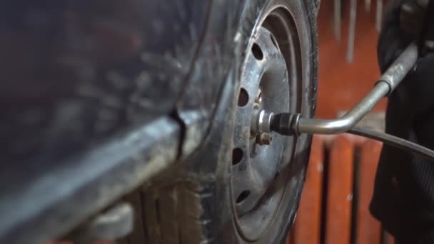 Profesional en taller de reparación de automóviles cambia rueda en coche de pasajeros — Vídeos de Stock