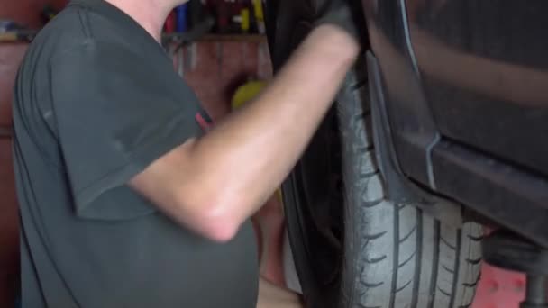 Een monteur repareert een auto in de garage. Auto service, reparatie en onderhoud — Stockvideo