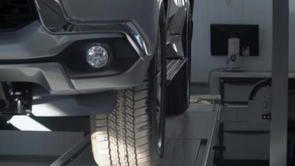 Hydraulic platform letting a car down in car repair shop. Car service — Stock Video