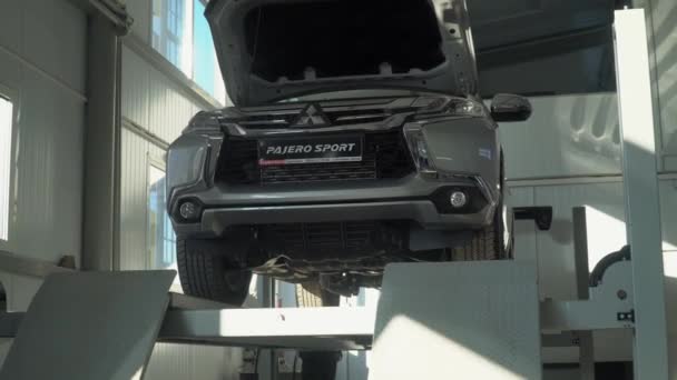 Ternopil, Ukraine - January 25, 2020: Hyhydraulic platform letting a car down in car repair shop Mitsubishi — 图库视频影像