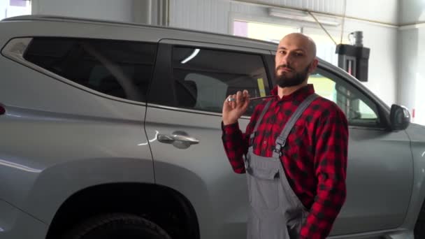 Mecânico barbudo na oficina de reparação automóvel. Serviço de carro, reparação e manutenção — Vídeo de Stock