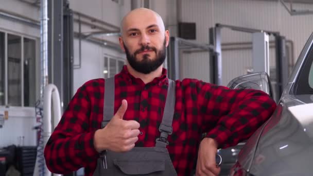 Mecánico barbudo en taller de reparación de automóviles. Servicio, reparación y mantenimiento de automóviles — Vídeos de Stock