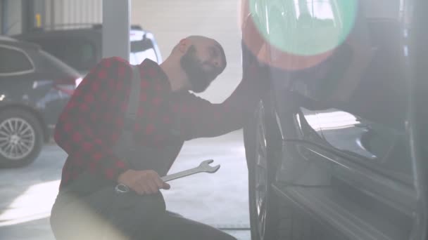 Hombre mecánico de reparación de un coche en el taller de reparación de automóviles. Servicio, reparación y mantenimiento de automóviles — Vídeos de Stock