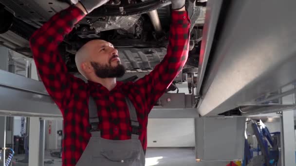 Hombre mecánico de reparación de un coche en el taller de reparación de automóviles. Servicio, reparación y mantenimiento de automóviles — Vídeos de Stock