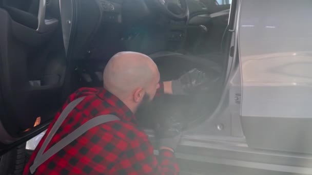 Vousatý mechanik opravující auto v opravně aut. Autoservis, opravy a údržba — Stock video