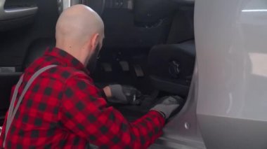 Tamirci adam araba tamirhanesinde araba tamir ediyor. Araba servisi, onarım ve bakım