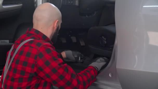 Человек-механик ремонтирует машину в автомастерской. Автосервис, ремонт и обслуживание — стоковое видео