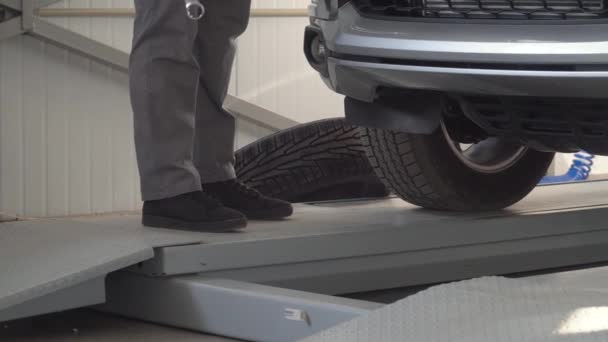 El mecánico deja caer una llave. Hombre mecánico de reparación de un coche en el taller de reparación de automóviles — Vídeo de stock