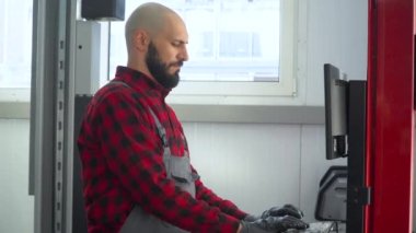 Profesyonel tamirci araba tamir istasyonunda bilgisayar kullanıyor