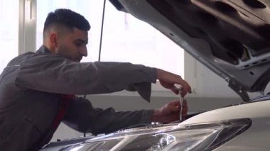 Araba tamirhanesinde araba tamir eden profesyonel bir tamirci. Araba servisi, onarım ve bakım