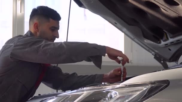 Profesjonalny mechanik naprawiający samochód w warsztacie samochodowym. Serwis, naprawa i konserwacja samochodów — Wideo stockowe