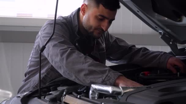 Professionell mekaniker som reparerar en bil i bilverkstaden. Bilservice, reparation och underhåll — Stockvideo
