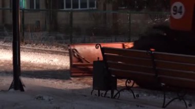 Tractor cleaning snow in the night city