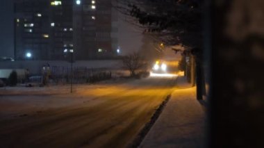 Tractor cleaning snow in the night city